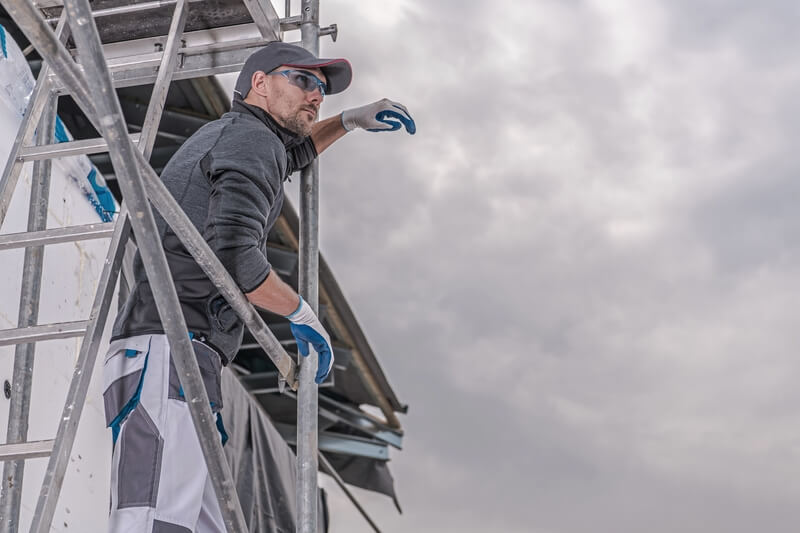 homem trabalhando nas alturas andaimes