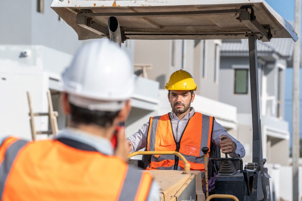 colaboradores trabalhando com compactador de terra