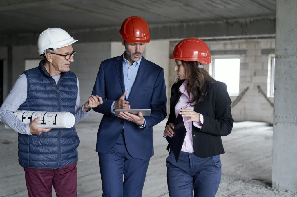 engenheiros de capacete olhando diário de obra
