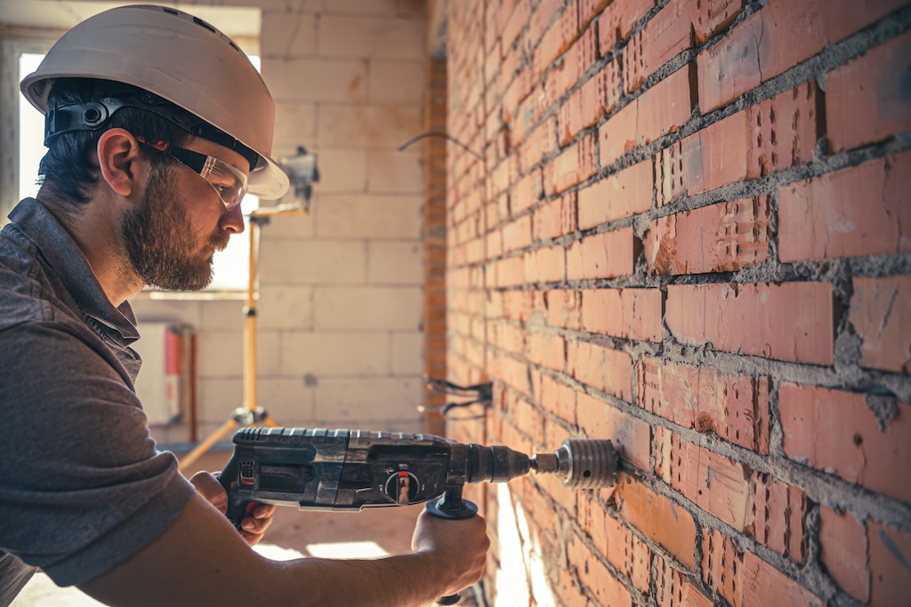 trabalhador em canteiro de obras com ferramenta equiloc